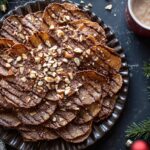 ray of chocolate-covered potato chips sprinkled with sea salt, surrounded by melted chocolate and plain chips on parchment paper.