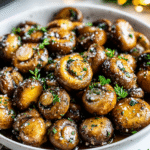 Garlic Butter Mushrooms Christmas Recipe in a black skillet with garlic herb butter and fresh parsley