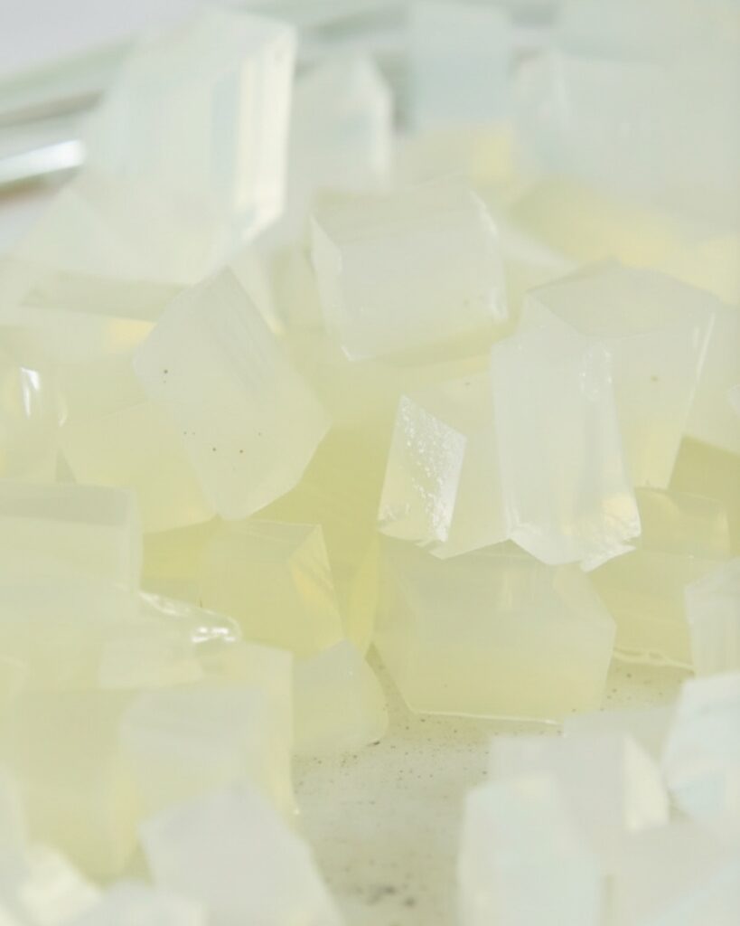 Top-down view of gelatin mixture setting in a glass container before chilling
