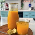 Traditional Jamu Juice Recipe (Indonesian Turmeric Ginger Drink) served in rustic clay cups with turmeric, ginger, and lime