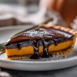 Glossy dark chocolate pumpkin tart with shiny ganache drip