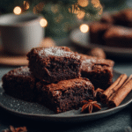 Fudgy gingerbread brownies with festive holiday spices on a ceramic plate