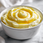 “creamy mashed potatoes recipe with buttery swirl on white marble”