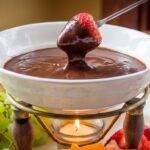 Easy chocolate fondue board with fruit, marshmallows, and pretzels