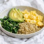 Healthy breakfast bowl for weight loss with eggs, quinoa, avocado, and greens