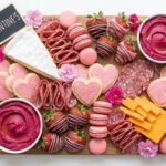 Galentine’s charcuterie board ideas with pink sweets, cheeses, and berries