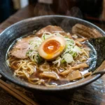 Bowl of ramen topped with a halved marinated ramen egg